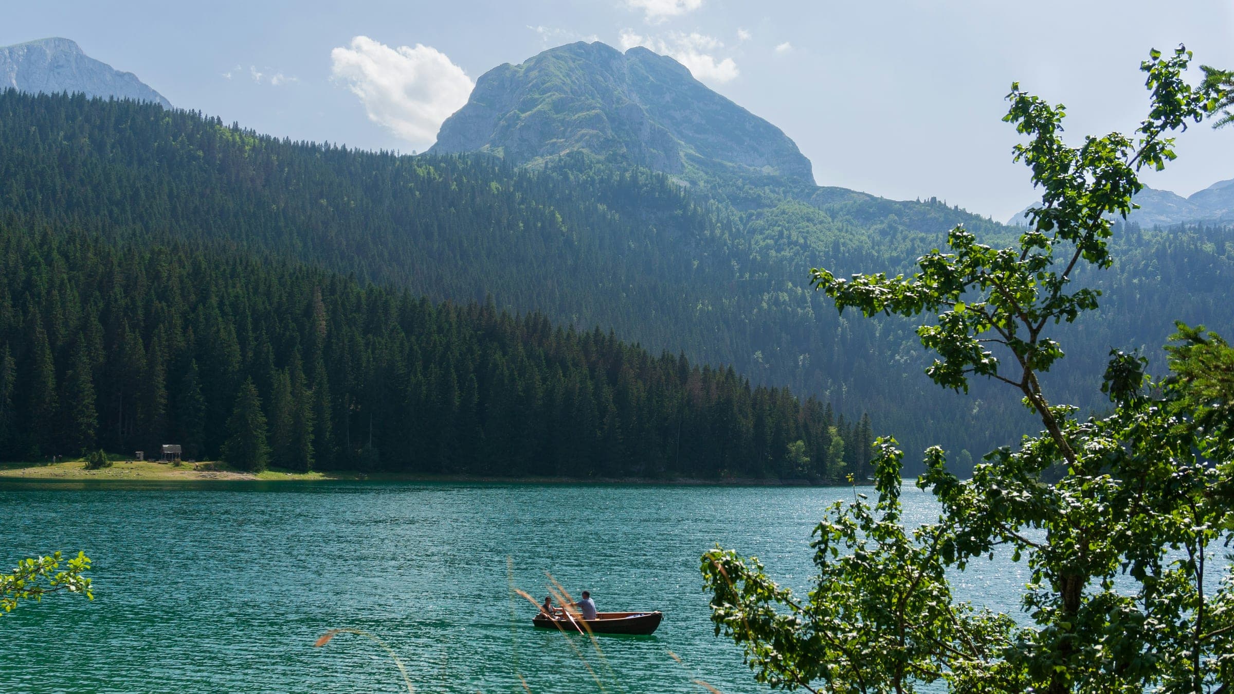 Black Lake in Durmitor National Park, Montenegro, with a rowing boat and the Međed peak